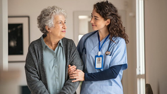 Caregiver assist senior woman at home